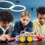 Young students focus on building a robotics project together, showcasing teamwork and creativity.